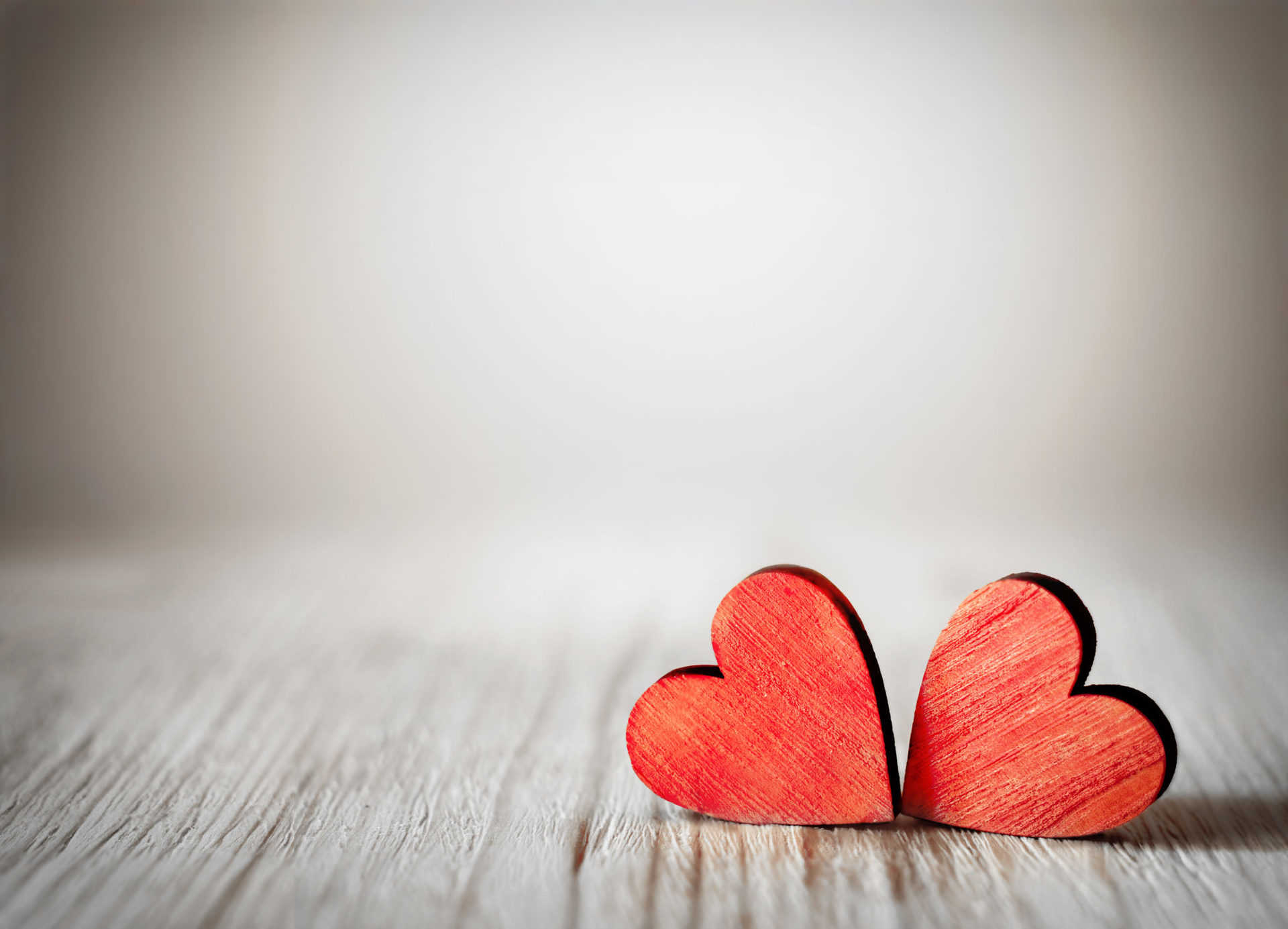 Heart-shaped wood carvings on a wooden table.