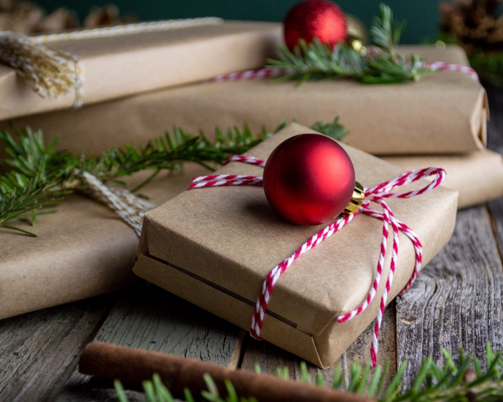Christmas presents wrapped in brown paper with red and white ribbon.