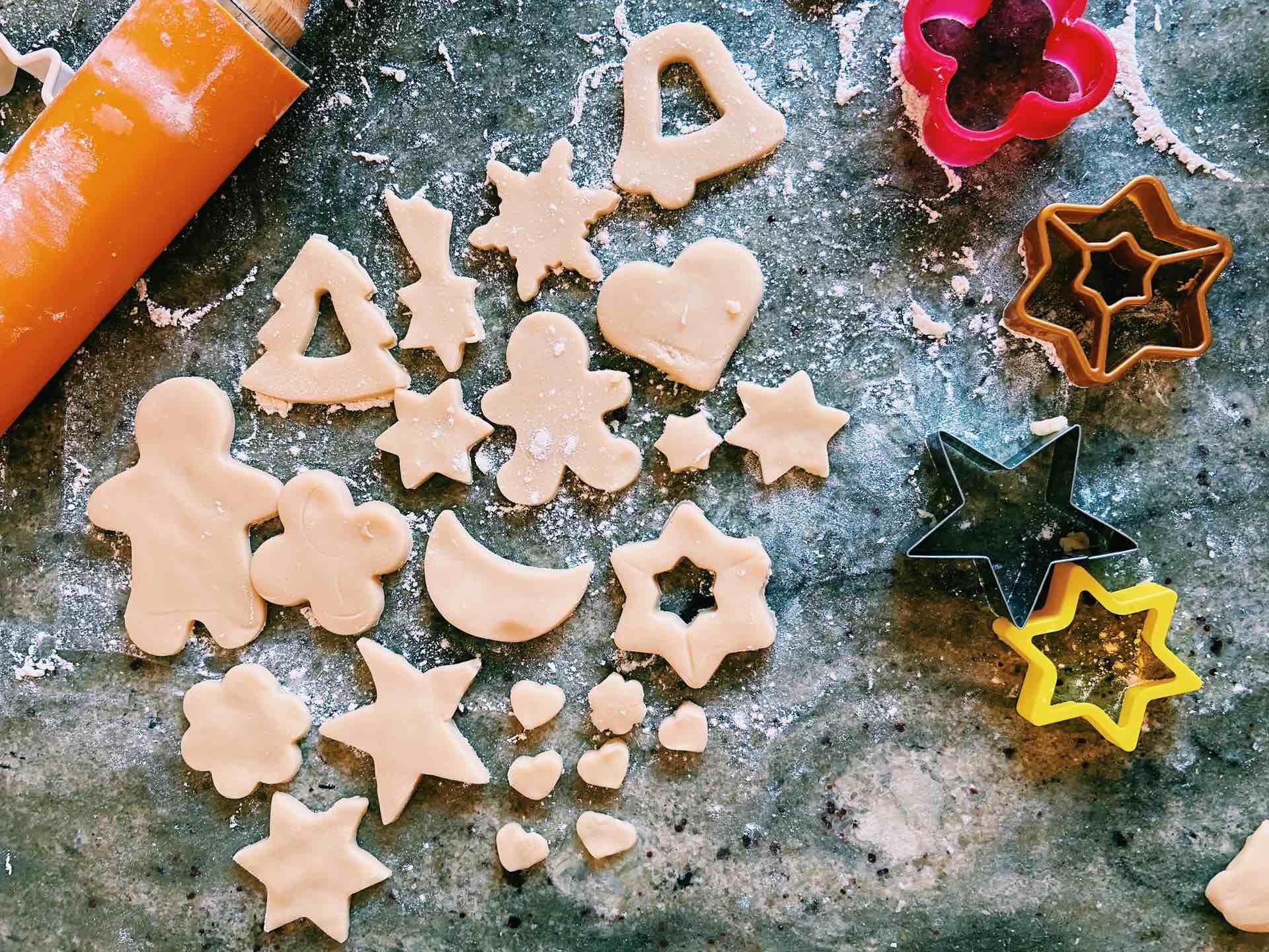 Cookie cutters and dough on a counter.