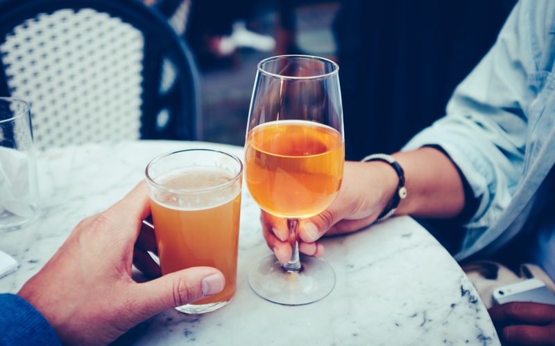 Two people toasting their drinks.