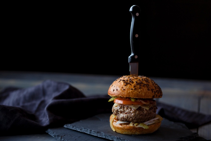 Hamburger with a knife through it.