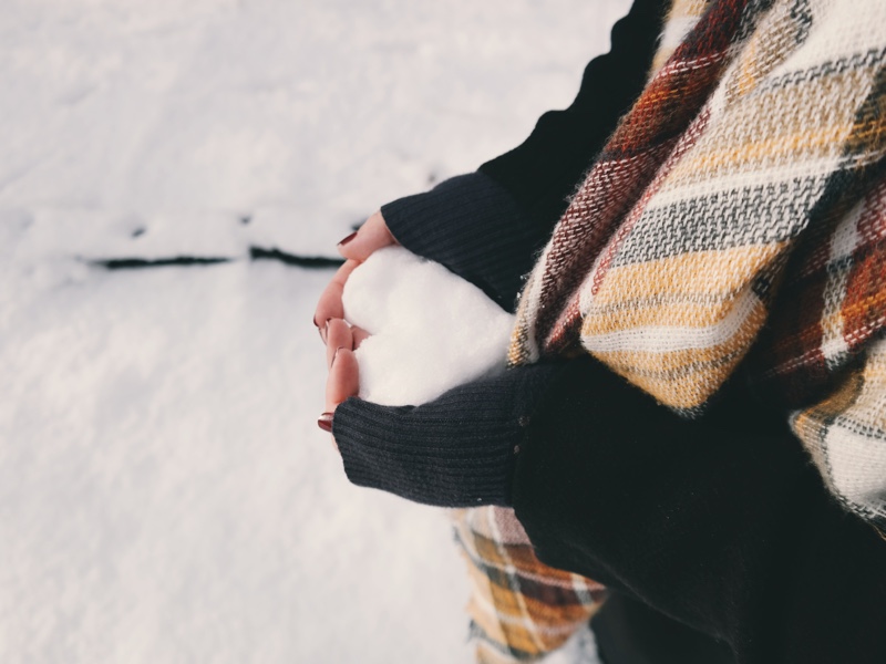 A person holding a heart-shaped snow.
