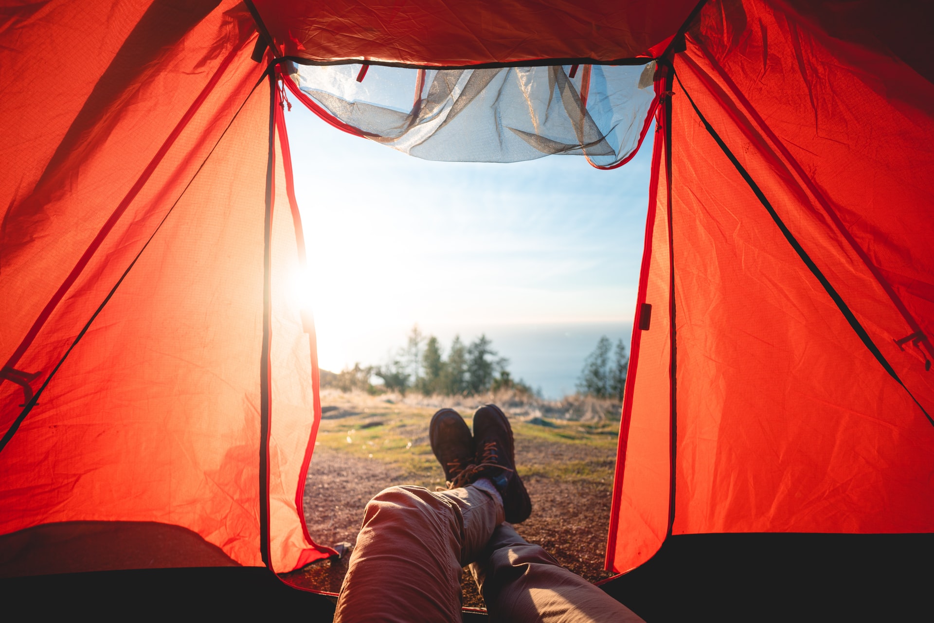 A person relaxing in a tent with their feet up, enjoying the peacefulness of the outdoors.