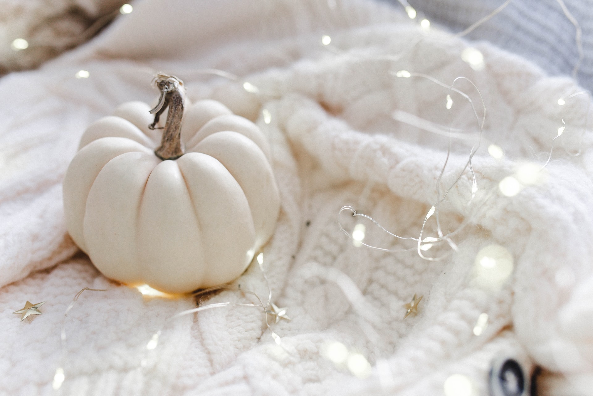 A white pumpkin resting on a soft blanket.