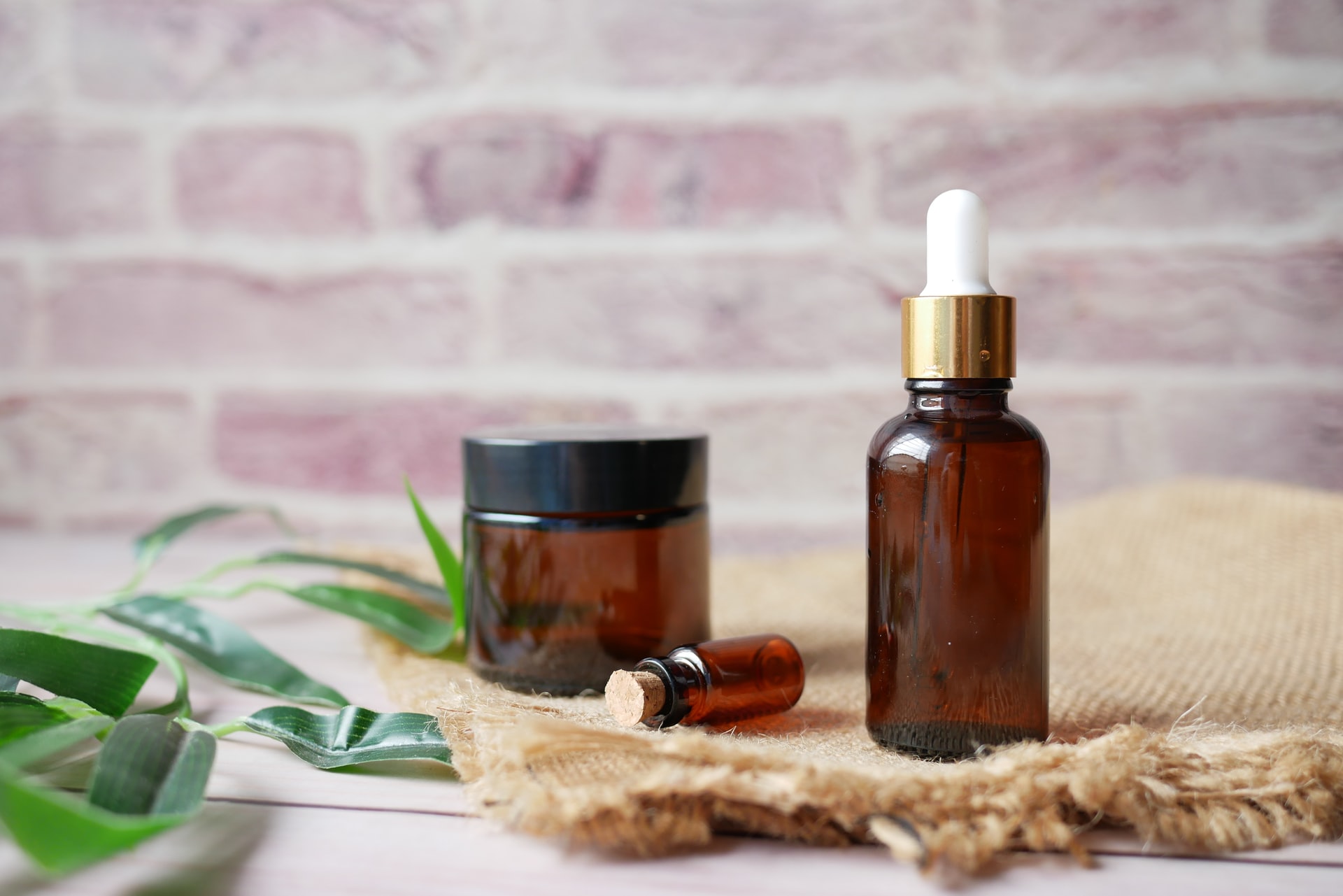 Glass bottles filled with essential oils on a wooden surface.