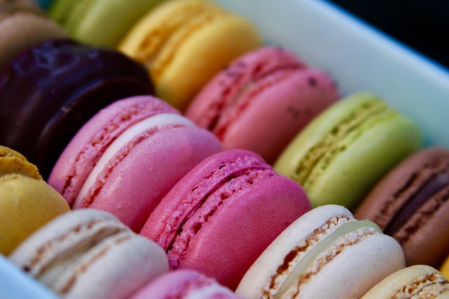 A colorful box of macarons, each one filled with a different flavor.